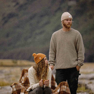 Man and woman wearing wool beanies drinking tea