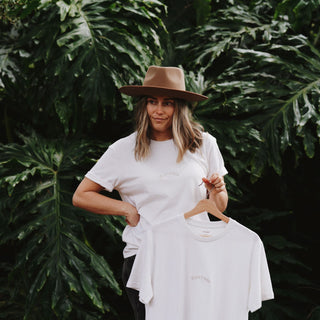 Woman wearing and holding organic and recycled cotton More Trees Tee