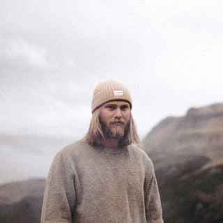 Man with long hair wearing beige cream Australian ribbed wool beanie