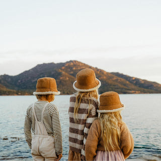 Family wearing the ugg wool bucket hat standing by the ocean