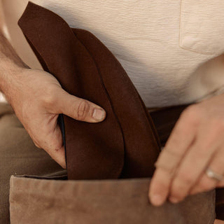Close-up of Anderson Brown hat and bag being packed in natural light