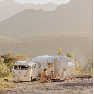 Mum with kids, van and caravan cooking a fire