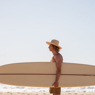 Man wearing wide brim straw beach hat Jude Sand by Will & Bear