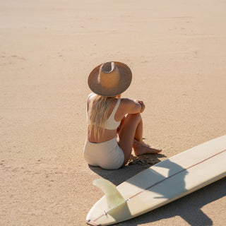 Woman wearing rustic straw beach hat Jude Sand by Will & Bear