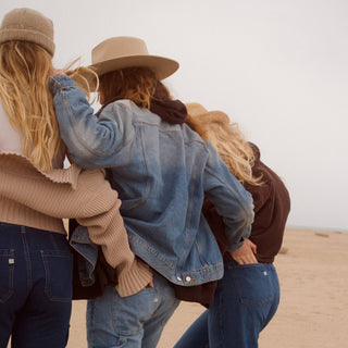 Three girls wearing hats and hugging