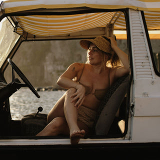 Lifestyle scene with Ari Sand straw visor hat packed for a summer trip