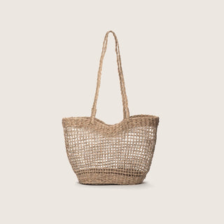Woven straw tote bag on a light beige background
