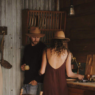 Man and woman having a cup of tea wearing wide-brim floppy hats