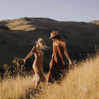 Women walking amongst the fields in wide-brim floppy hats