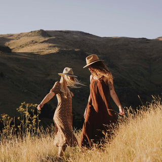 two women wearing wide brim floppy hats