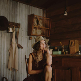 Woman relaxing on a chair wearing a wide-brim floppy hat