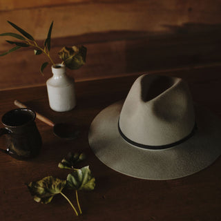 Close up view of a wide brim floppy hat ojn a wooden table