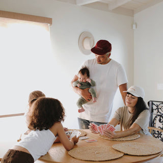 Family playing cards while wearing the Archie MAroon 5 panel cap