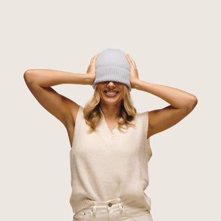 Woman wearing Bambi Dust Blue knit beanie covering her eyes holding her head