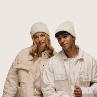 Guy and girl standing next to each other wearing Bambi Sage Green knit beanie