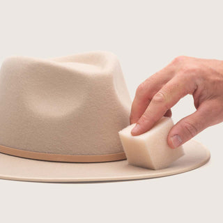 Hat cleaning sponge being used on a felt hat to remove dirt