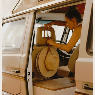 Leather hat holder hanging cowboy hat from car headrest