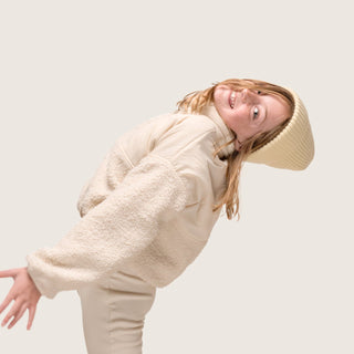 Little girl having fun in the Little Bambi Custard butter knit beanie