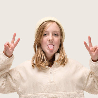 Girl throwing peace signs wearing  Little Bambi Custard yellow butter knit beanie