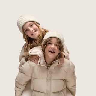 Boy giving girl a piggy back wearing Little Bambi Sage green knit beanie 