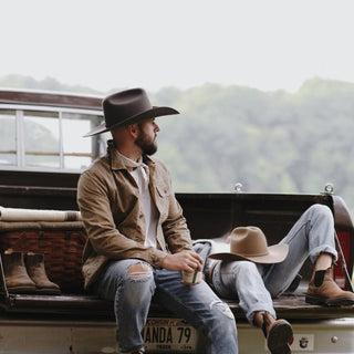 Men sitting on the edge of a truck wearing the Will & Bear Buck Smoke black felt cowboy hat, styled for rugged outdoor comfort.