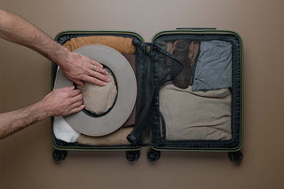 Hat being packed in a carry on suitcase