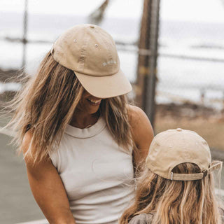 Mother and daughter smiling and wearing baseball caps