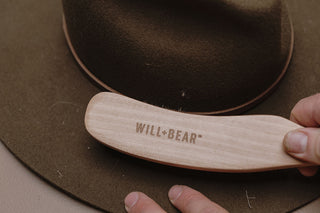 Close up of hat brush cleaning hat