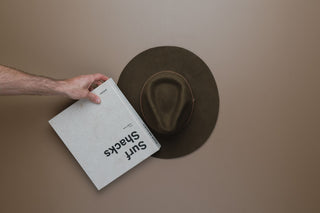 Placing a book on a hat to flatten the brim