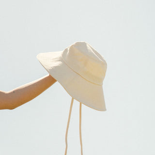 women holding white cream bucket hat