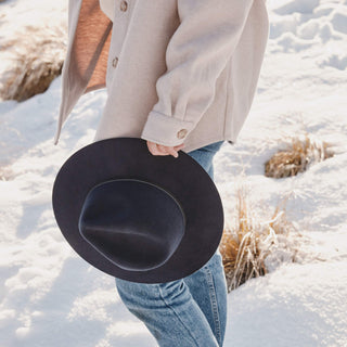 Traveler holding Will & Bear Anderson Navy Soft Felt Fedora, ready for mountain adventures