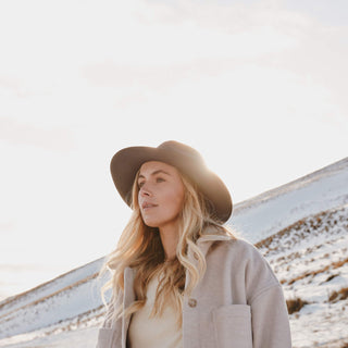 Woman wearing Will & Bear Anderson Navy Soft Felt Fedora in snow-covered landscape, built for modern explorers