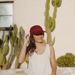 Female traveler wearing Will & Bear Archie Maroon 5-Panel Vintage Cap styled for sunny days and outdoor exploring
