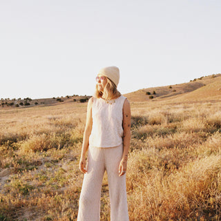Woman in wide landscape wearing the Will & Bear Bambi Apricot merino wool beanie, perfect for outdoor adventures.