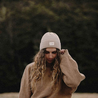 Woman staying warm in Will & Bear Beige Wool Beanie during outdoor winter adventure