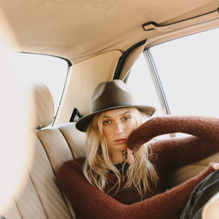 Woman leaning through van window wearing Will & Bear Crushable Travel Hat, made for flexible road trips