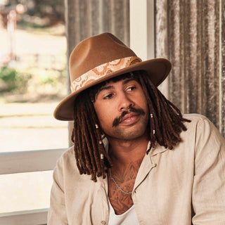 Man wearing a wide brim hat styled with the Will & Bear Hat Scarf Mustard as a decorative wrap band.