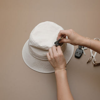 Demonstration of external pocket on the Will & Bear Billie Bone bucket hat, highlighting its functional and versatile design.