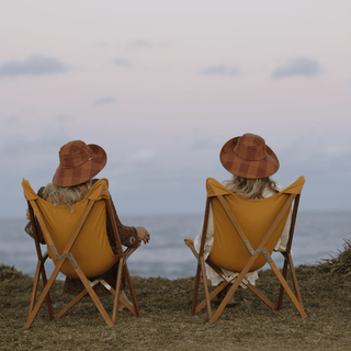 Two Will & Bear x Wandering Folk Slow Road Camp Chairs set up at a scenic sunset lookout facing the ocean.