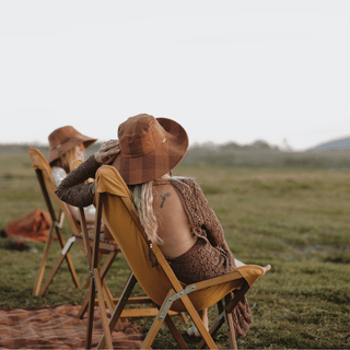 Two people relaxing in Will & Bear x Wandering Folk Slow Road Camp Chairs in an open field, enjoying the outdoors.