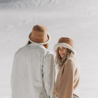 Man and woman wearing Will & Bear Wool UGG Bucket Hats during snowy mountain adventure