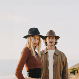 Woman wearing William Black wide-brim fedora wool hat and man wearing wide-brim brown fedora