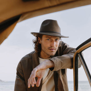 Man wearing William Brown wide-brim wool fedora leaning on an open car door