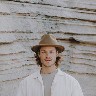 Man standing in cave, looking at the camera wearing William Oak Borwn wide-brim wool fedora hat