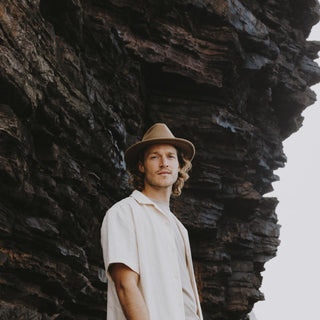 Man standing under a cliff wearing William Oak brown wide-brim soft wool hat