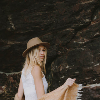 Woman standing under cliff wearing womens William Oak brown wide-brim wool fedora