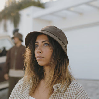 Woman wearing a brown string bucket hat with loose waves