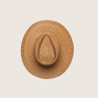 A natural straw cowboy hat viewed from directly above, centered on a solid light beige background.