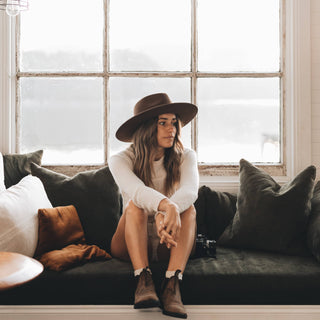 Female explorer wearing Will & Bear Andy Auburn Dark Brown Country Hat indoors, perfect for everyday style and travel
