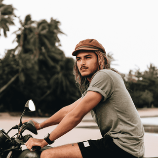 Man riding a motorbike wearing the Will & Bear Baker Tan brown cord bakerboy cap.